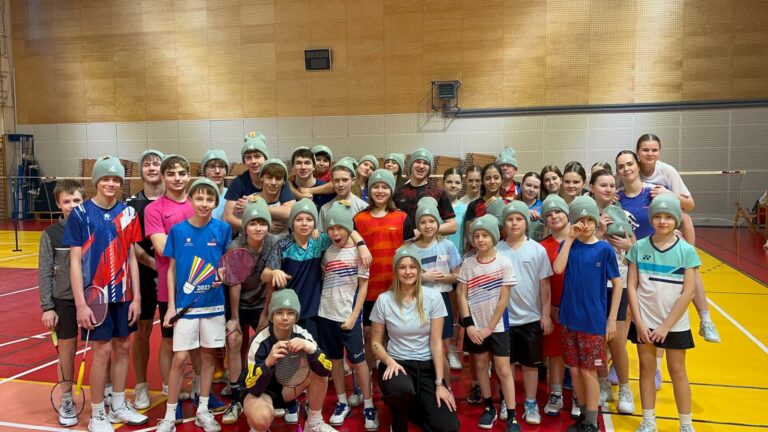 Międzynarodowy Zimowy Obóz Badmintona 2026 - zdjęcie grupowe uczestników w pamiątkowych czapkach obozowych