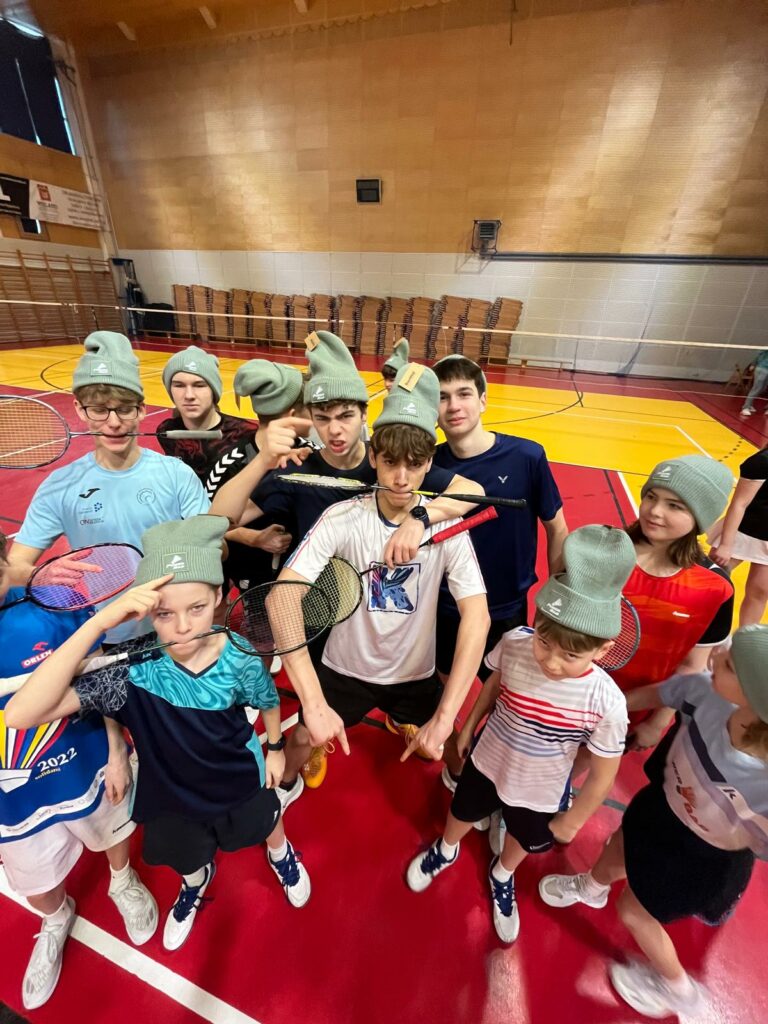 Międzynarodowy Zimowy Obóz Badmintona 2026 - zdjęcie grupowe uczestników w pamiątkowych czapkach obozowych